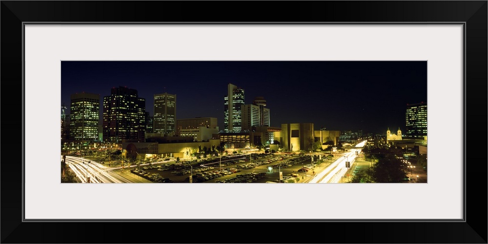 Panoramic canvas of buildings in Phoenix illuminated at night.