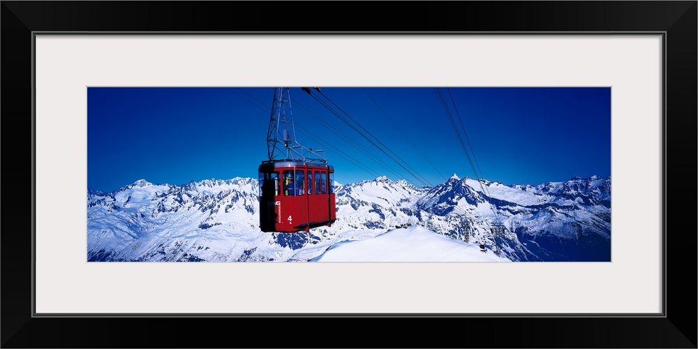 An aerial tramway overlooking the snowcapped mountains in Andermatt, Switzerland.