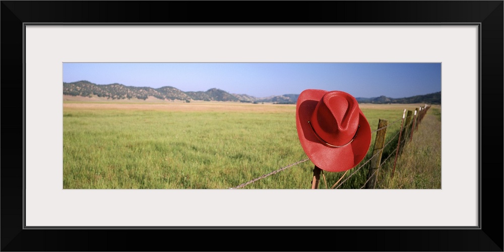 California, Red cowboy hat hanging on the fence