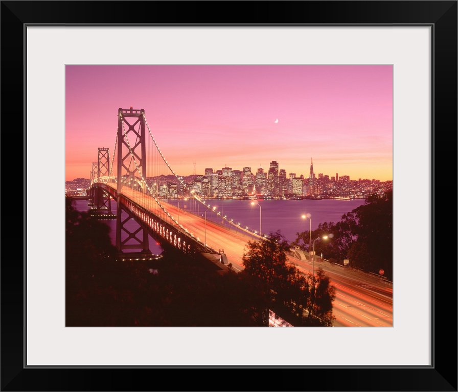 Big photograph displays a large overpass near the coast of the Western United States brightly shining in the dimming light...