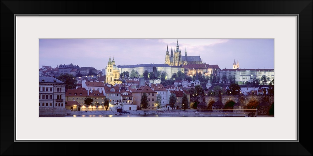 Wide angle photograph of buildings in Prague, Czech Republic, lit up at night, including Hradcany Castle.