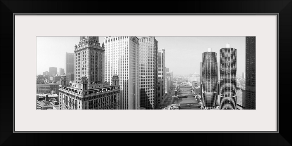 Huge monochromatic photograph taken from an aerial view looks down a river encased by tall skyscrapers within the largest ...