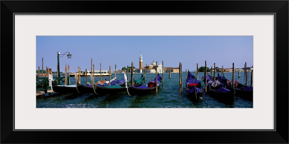 Long photo on canvas of gondolas parked  near posts in Italy.