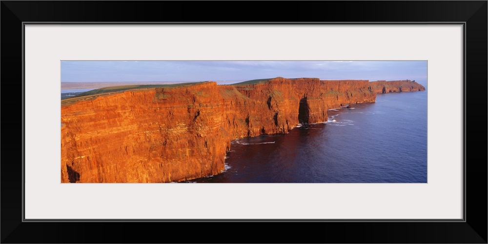 Orange-red cliffside of the Cliffs of Moher County in Clare, Ireland.