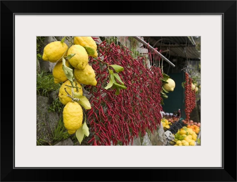 Lemons and chili peppers in Italy hang for sale in a local farmers market.