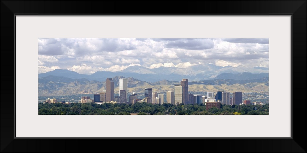 Panoramic photograph shows a line of skyscrapers in a capital city within the Midwestern United States during a cloud-fill...