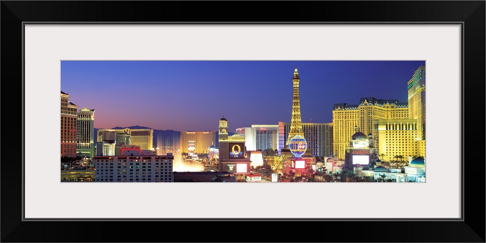 Panoramic photograph showcasing the bright neon lights of the busy strip in Las Vegas, Nevada at dusk.  Hotels and casinos...