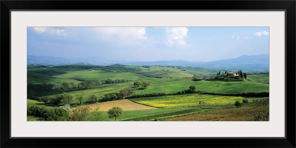 Vast land and large green fields in Italy are pictured in a wide angle view.