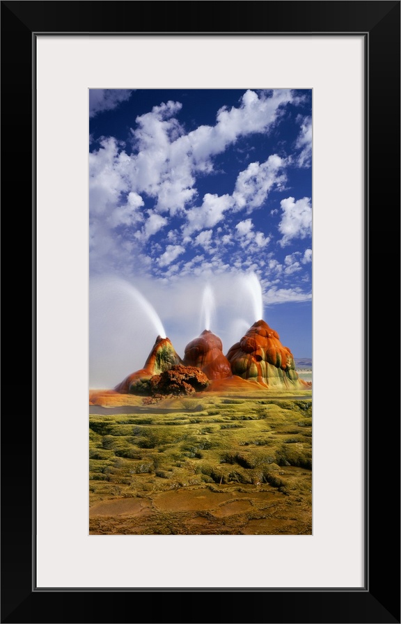 Vertical panoramic photograph of huge rock formations in desert under a cloudy sky.