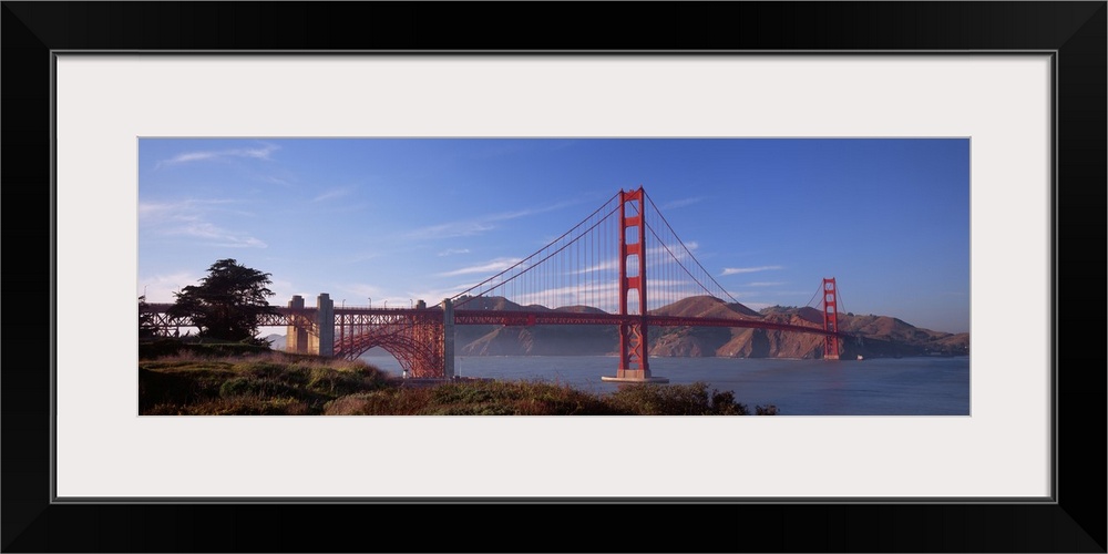 Panoramic photograph showcases a famous suspension bridge found within the Western United States on a sunny day.  The intr...