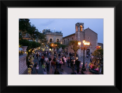 Group of people on the street at dusk, Piazza IX Aprile, Taormina, Sicily, Italy