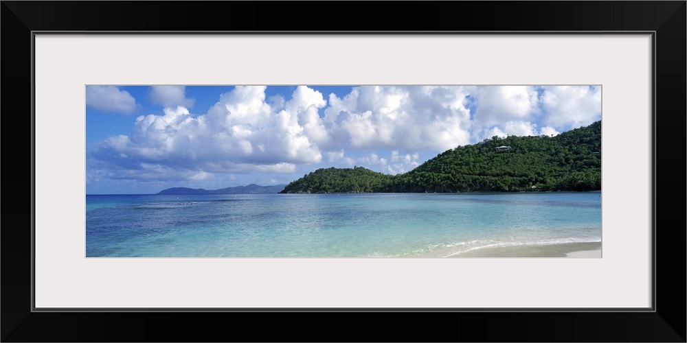 Panoramic photo on canvas of a clear ocean meeting a shore with rolling hills on the right side.