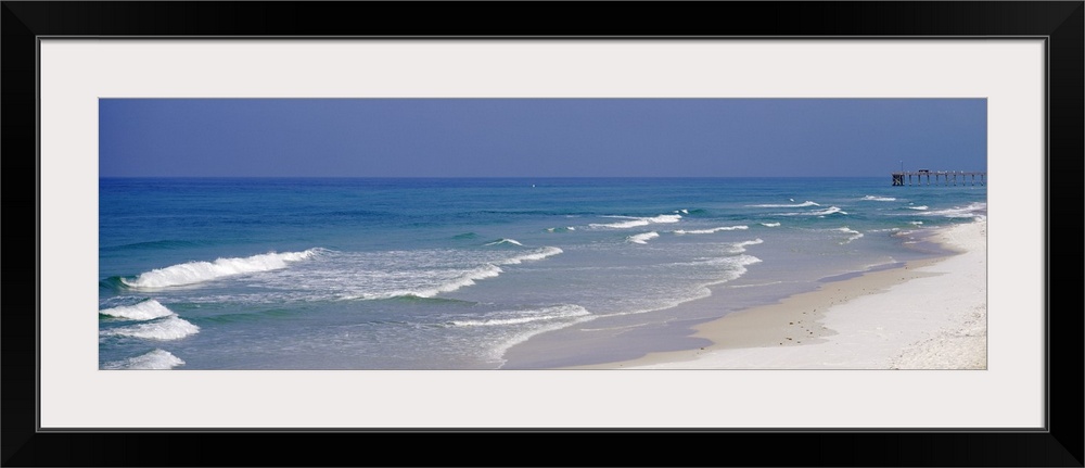 Panoramic photo of waves rushing onto the sandy shoreline in Florida, on the coast of the Atlantic ocean, with a small pie...