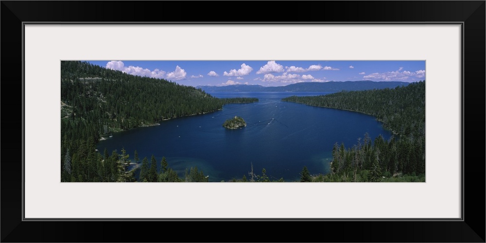 Big panoramic photo of Lake Tahoe, California (CA). The land surrounding the lake is covered with thick forest and boats a...