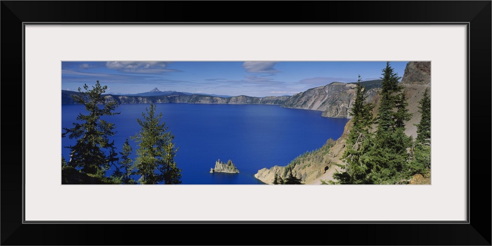 Panoramic photograph taken from an aerial view overlooking a large body of water surrounded by mountainous terrain in the ...