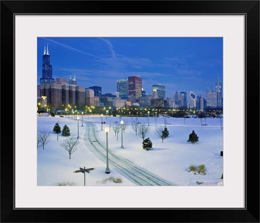 A photograph of a city park buried in fresh snow and the city skyscrapers available of as a large print.