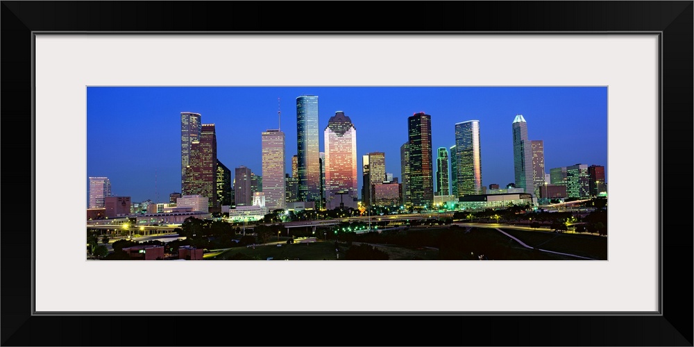 Decorative artwork for the home or office this photograph captures the city skyline and surrounded road ways on a panorami...