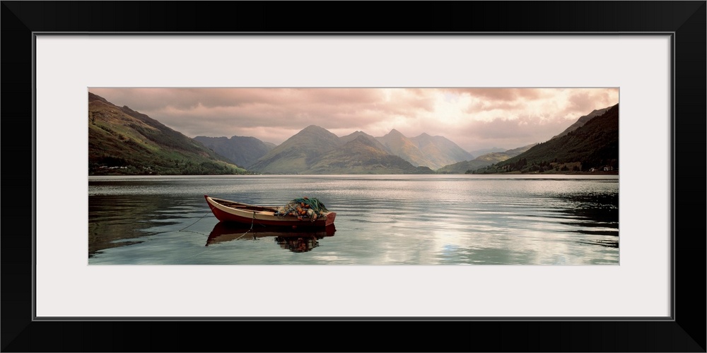 Panoramic photograph shows a small fishing vessel sitting anchored within a calm body of water north of the United Kingdom...