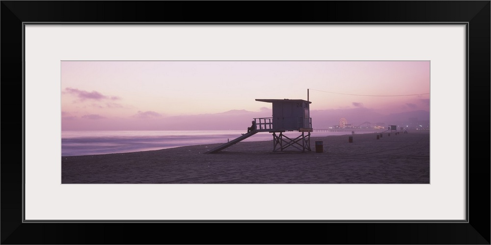 Long horizontal photo print of a lifeguard station on the beach along the Pacific ocean with the Santa Monica Pier in the ...