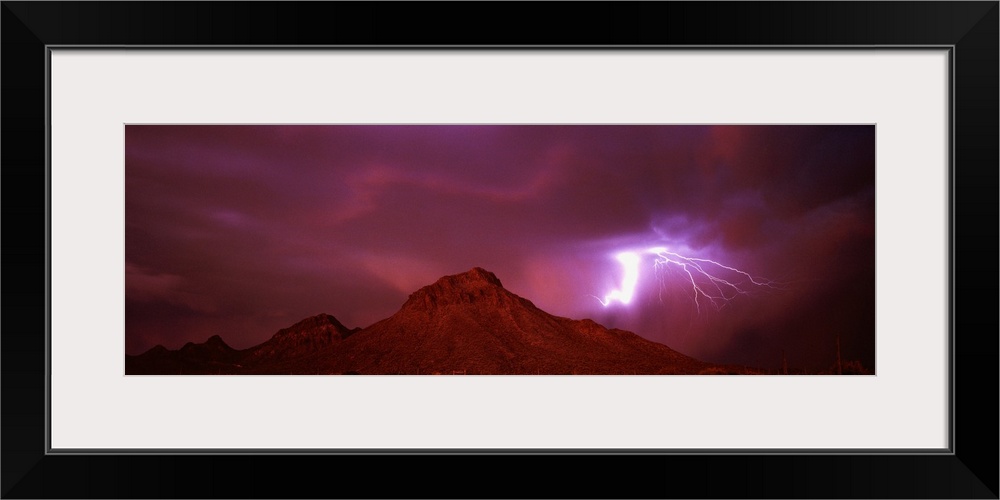Panoramic painting of mountain range under a dark cloudy sky with bolts of lightning.