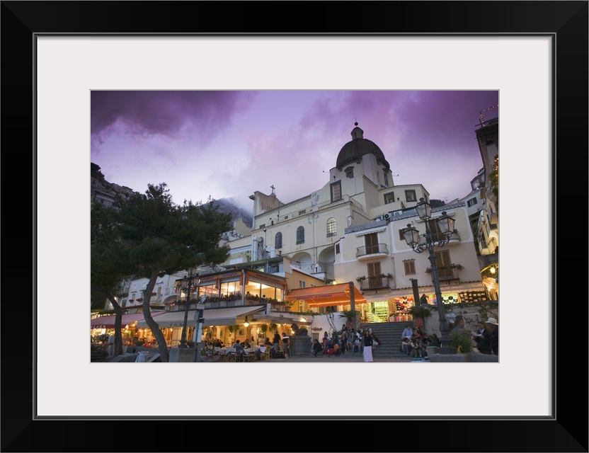 A large church is photographed from street view and illuminated under a purple sky.