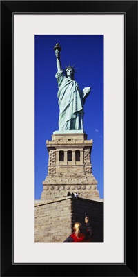 Low angle view of a tourist taking a picture of a statue, Statue of Liberty, Liberty State Park, Liberty Island, New York City, New York State