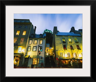 Low angle view of buildings lit up at dusk, Quebec, Canada