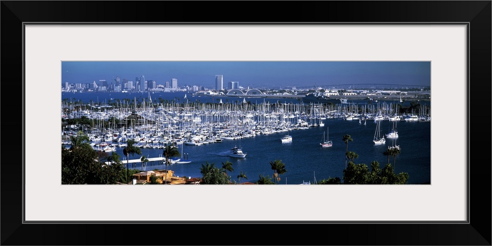 Panoramic photograph on a large wall hanging of a marina packed with boats, in front of the San Diego skyline on the dista...