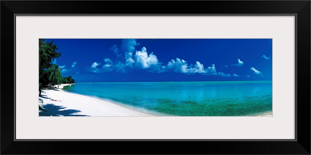 Oversized wall hanging of a sunlit shoreline in Bora Bora, Polynesia with calm waters leading into the horizon.