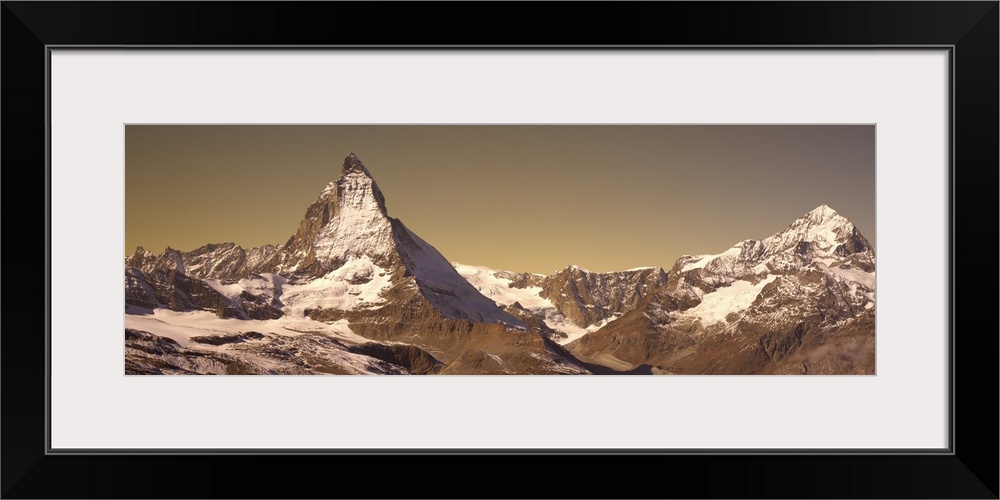 Large, landscape photograph of Matterhorn mountain, lightly covered with snow, in Switzerland.