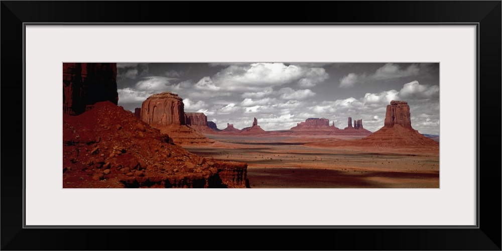 Selective color photograph of the Arizona desert landscape. The rocky landscape remains in color under a black and white sky.