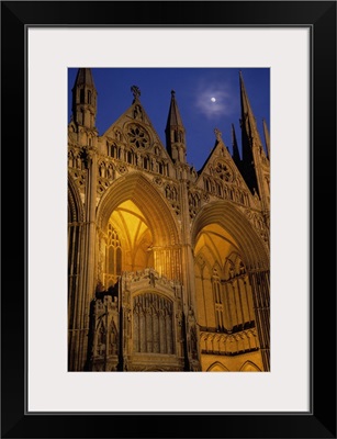 Moon over Peterborough Cathedral illuminated at night, Peterborough, England.