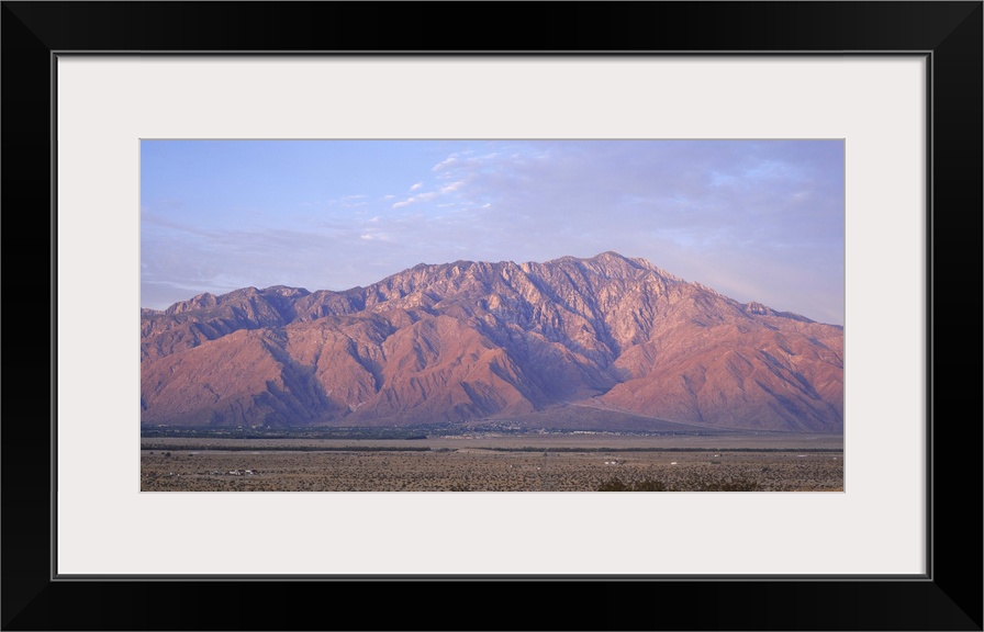 Wide angle picture of San Jacinto Peak in California. The sun is setting out of view and shining onto the mountain range.