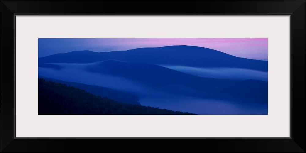 Panoramic photograph on a big wall hanging of shadowed mountains at sunset at Acadia National Park, in Maine.