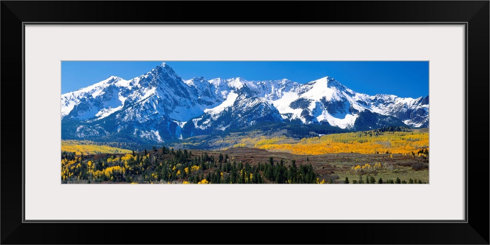 Panoramic image of a wilderness area at the base of a snowy mountain range.