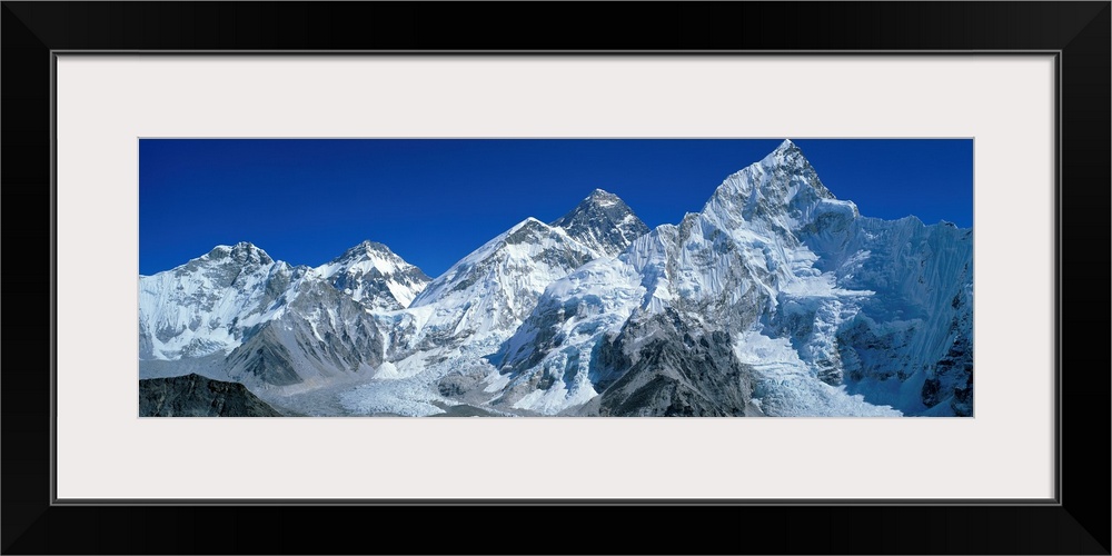Giant, wide angle landscape photograph of snow covered Himalaya Mountains against a blue sky, including Mt Chungsi, Mt Eve...