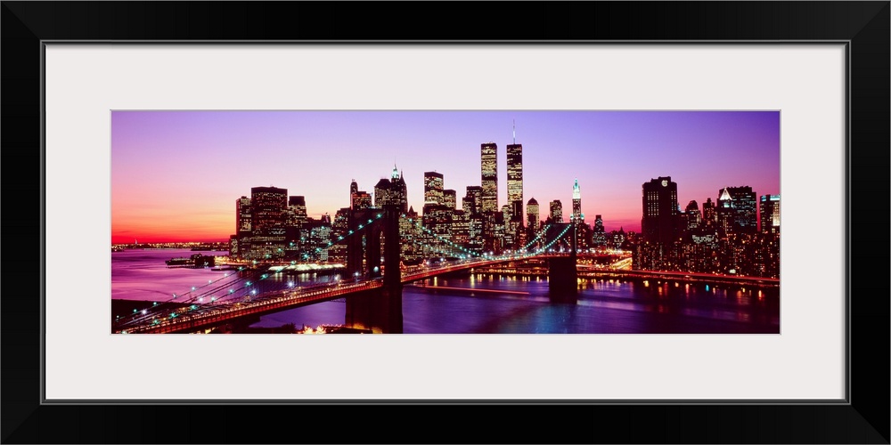 Large artwork for a living room of office of the Brooklyn Bridge and Manhattan with lights shining in the evening sky.