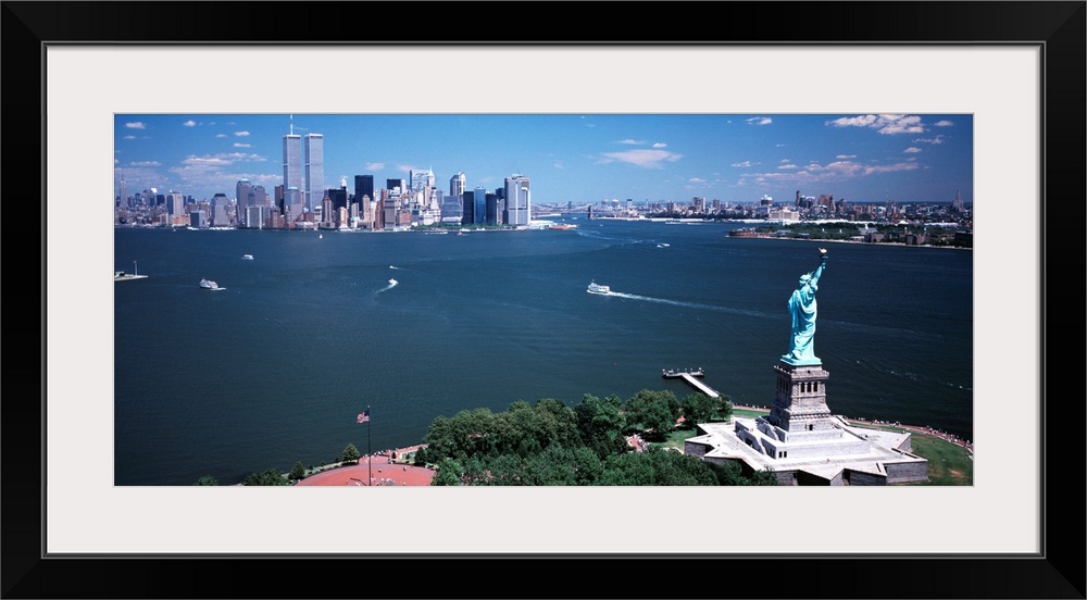 Big, horizontal photograph of the Statue of Liberty and the New York Harbor.  The New York City skyline in the background.