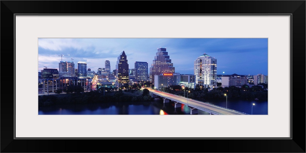 Panoramic photograph taken within the capital city of Texas shows the skyline at nighttime sitting in front of the Colorad...
