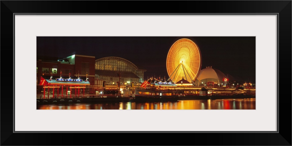 Panoramic photo on canvas of the navy pier lit up at night along a waterfront with a ferris wheel.