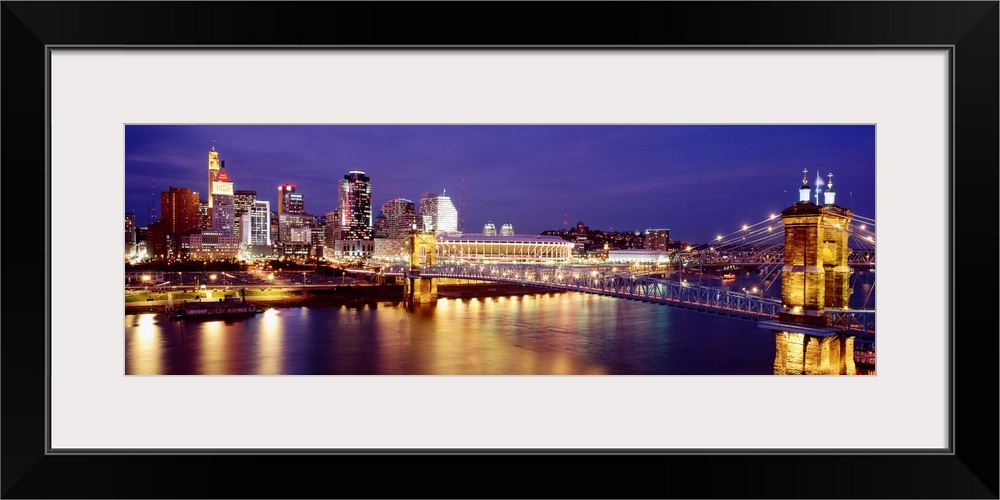 Horizontal photograph on a large canvas of the night lights of Cincinnati's downtown waterfront and bridge over the Ohio R...