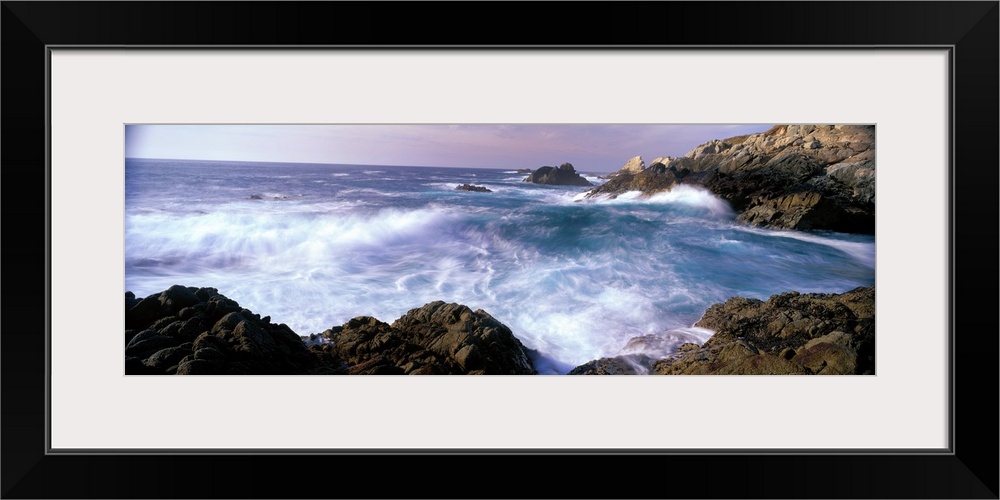 Panoramic photograph on a large canvas of ocean waves crashing into the rocks near San Simeon Point, California.