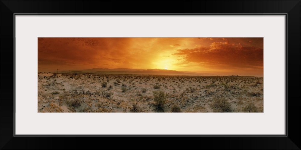Big, horizontal photograph of a fiery sunset over the desert in Palm Springs, California.