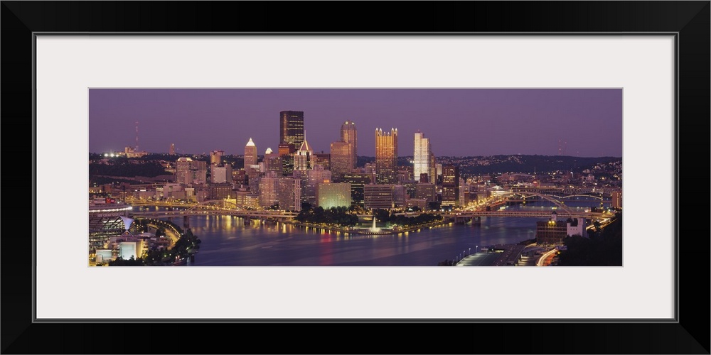 This oversized wall art is a panoramic photograph of the cityos downtown captured from the south above the river.