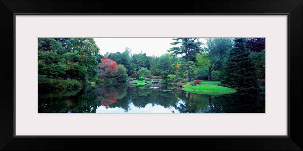 Panoramic photograph of the vibrant Asticou Azalea Garden reflecting in the water of a large pond, in Northwest Harbor, Ma...