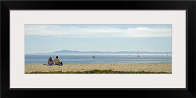Rear view of a couple sitting on the beach, Channel Islands, Santa Barbara, California