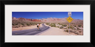 Rear view of a person cycling on the road, Red Rock Canyon National Conservation Area, Clark County, Nevada