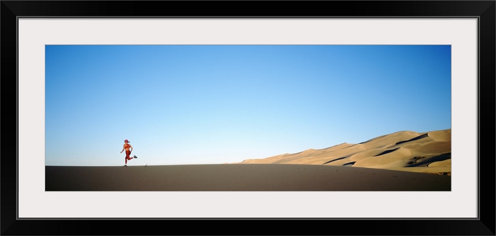 Rear view of a woman running in the desert, Great Sand Dunes National Monument, Colorado