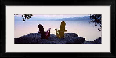 Red and Yellow Adirondack chairs on a rock near a lake, Champlain Lake, Vermont