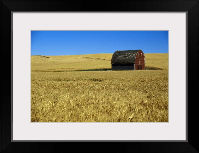 Large wall art of a barn in the middle of a field printed on canvas.